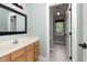 Bathroom with wooden vanity and tile floor leading to shower and toilet room at 120 Cypress View Way, Apex, NC 27502