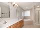 Bathroom with double sink vanity, a soaking tub, and a glass-enclosed shower at 120 Cypress View Way, Apex, NC 27502