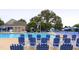 Well maintained pool with many lounge chairs and umbrellas surrounded by lush trees at 120 Cypress View Way, Apex, NC 27502