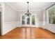 Bright dining room featuring beautiful hardwood floors, elegant wainscoting, and access to the deck at 120 Cypress View Way, Apex, NC 27502
