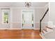 Inviting entryway with hardwood floors, stairs, and a white front door with sidelights under an elegant light fixture at 120 Cypress View Way, Apex, NC 27502