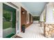Inviting front porch with white columns, a wooden swing, and a view of the surrounding greenery at 120 Cypress View Way, Apex, NC 27502