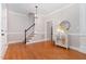 Hallway with hardwood floors, staircase, and decorative table under a decorative mirror in a neutrally painted room at 120 Cypress View Way, Apex, NC 27502
