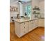 Kitchen island with granite countertop, white cabinets, and hardwood floors at 120 Cypress View Way, Apex, NC 27502