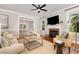 Cozy living room featuring a fireplace, large TV, comfortable seating, and open view into the dining area at 120 Cypress View Way, Apex, NC 27502