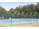 Community tennis court with blue and green surfaces, surrounded by mature trees and green fencing at 120 Cypress View Way, Apex, NC 27502