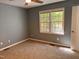 Bright bedroom with natural light, neutral paint and carpet, and a view of the surrounding trees at 1204 Amberstone Dr, Knightdale, NC 27545