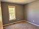 Cozy bedroom with a large window, neutral walls and carpet, creating a serene and inviting space at 1204 Amberstone Dr, Knightdale, NC 27545