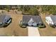 Aerial view of a well-maintained home with a spacious lawn, driveway, and lush surrounding greenery at 123 Ariel St, Lillington, NC 27546