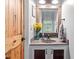 Charming bathroom with a rustic vanity, decorative mirror, and a unique wooden door at 147 W Alex Dr, Clayton, NC 27520