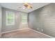 Bedroom features a stylish accent wall and windows overlooking greenery, creating a refreshing and inviting atmosphere at 147 W Alex Dr, Clayton, NC 27520