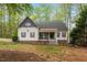Charming two-story home featuring red shutters, covered porch and lush, mature landscaping at 147 W Alex Dr, Clayton, NC 27520
