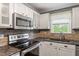 Modern kitchen featuring stone backsplash, stainless steel appliances, and sleek countertops creating a stylish culinary space at 147 W Alex Dr, Clayton, NC 27520