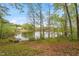 Beautiful lake view with a dock and the house nestled amongst the trees in the background at 147 W Alex Dr, Clayton, NC 27520
