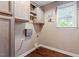 The laundry room features custom cabinetry and a window providing natural light at 147 W Alex Dr, Clayton, NC 27520