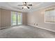 Spacious bedroom with tray ceilings, ceiling fan, and a private access door to the outside at 147 W Alex Dr, Clayton, NC 27520