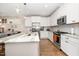Modern kitchen featuring white cabinets, stainless steel appliances, and a marble-top kitchen island with seating at 149 Logbridge Rd, Chapel Hill, NC 27516