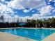 Outdoor swimming pool with lounge area surrounded by mature trees and blue skies at 149 Logbridge Rd, Chapel Hill, NC 27516