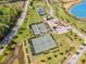 Aerial view of community tennis courts, clubhouse, and green spaces near a serene lake at 149 Logbridge Rd, Chapel Hill, NC 27516