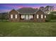 Inviting brick home featuring a cozy front porch and lush green lawn at 1500 Antioch Rd, Rocky Mount, NC 27801