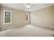 Spacious bedroom with neutral carpet, a ceiling fan, crown moulding, and two windows for natural light at 1515 Poets Glade Dr, Apex, NC 27523