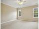 Large bedroom featuring neutral carpet, a ceiling fan, crown moulding, and two windows for natural light at 1515 Poets Glade Dr, Apex, NC 27523