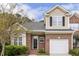 Charming two-story home featuring brick and siding exterior, attached garage, and well-manicured landscaping at 1515 Poets Glade Dr, Apex, NC 27523