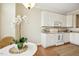 Well-lit kitchen with white cabinetry, modern appliances, and hardwood floors with a rug accent at 1515 Poets Glade Dr, Apex, NC 27523