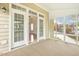 Inviting screened porch featuring neutral carpeting and double doors leading to the home's interior at 1515 Poets Glade Dr, Apex, NC 27523