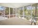 Bright sunroom with floor-to-ceiling windows offering scenic views of the surrounding landscape and nearby lake at 1515 Poets Glade Dr, Apex, NC 27523