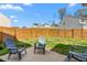 Relaxing backyard with a wood fence, concrete patio, and comfortable seating under a blue sky at 1725 Langlais Dr, Graham, NC 27253