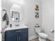 Stylish powder room with modern wallpaper, a round mirror, and a blue vanity with white countertops at 1725 Langlais Dr, Graham, NC 27253