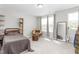 A bedroom is filled with light and features a bed, chair, shelves, and a floor mirror at 1725 Langlais Dr, Graham, NC 27253