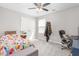 This bedroom features a ceiling fan, light walls, a closet, and a comfortable desk area at 1725 Langlais Dr, Graham, NC 27253