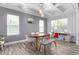 Well-lit dining room featuring a coffered ceiling, modern light fixture, and wood laminate flooring at 1725 Langlais Dr, Graham, NC 27253