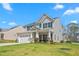 Charming two-story home on a lush lawn, featuring an attached garage and covered porch at 1725 Langlais Dr, Graham, NC 27253