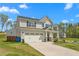 Two-story home with an attached garage, covered porch, and a well-maintained lawn at 1725 Langlais Dr, Graham, NC 27253