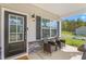 Covered front porch featuring a charming seating area and stylish front door at 1725 Langlais Dr, Graham, NC 27253
