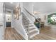 Hallway and staircase featuring modern decor and plank flooring, leading to additional living spaces at 1725 Langlais Dr, Graham, NC 27253
