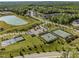 Community aerial view showcasing amenities like tennis courts, a pond, and lush green spaces at 173 Hawk Point Rd, Chapel Hill, NC 27516