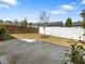 Fenced backyard featuring a concrete patio, young tree, and privacy landscaping at 173 Hawk Point Rd, Chapel Hill, NC 27516