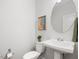Bright half bath features a round mirror, pedestal sink, and modern decor at 173 Hawk Point Rd, Chapel Hill, NC 27516