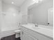 Bathroom with dark tile floors, white vanity and tiled tub and shower at 173 Hawk Point Rd, Chapel Hill, NC 27516