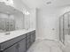 Bathroom featuring a double vanity, expansive mirror, marble tile flooring and walk-in glass shower at 173 Hawk Point Rd, Chapel Hill, NC 27516