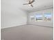 Spacious bedroom featuring carpet, ceiling fan, and three large windows that provide ample natural light at 173 Hawk Point Rd, Chapel Hill, NC 27516