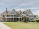 Exterior elevation of a multi-story clubhouse with stone accents and multiple decks at 173 Hawk Point Rd, Chapel Hill, NC 27516