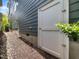 Side of home with white storage access door and gravel landscaping along the foundation at 173 Hawk Point Rd, Chapel Hill, NC 27516