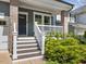 View of the front porch with white railings and wooden stairs, complemented by lush greenery at 173 Hawk Point Rd, Chapel Hill, NC 27516