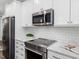 Modern kitchen with stainless steel appliances, white subway tile backsplash, and ample countertop space for meal preparation at 173 Hawk Point Rd, Chapel Hill, NC 27516