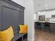 Hallway with dark gray mudroom bench with yellow pillows leads to the open kitchen at 173 Hawk Point Rd, Chapel Hill, NC 27516
